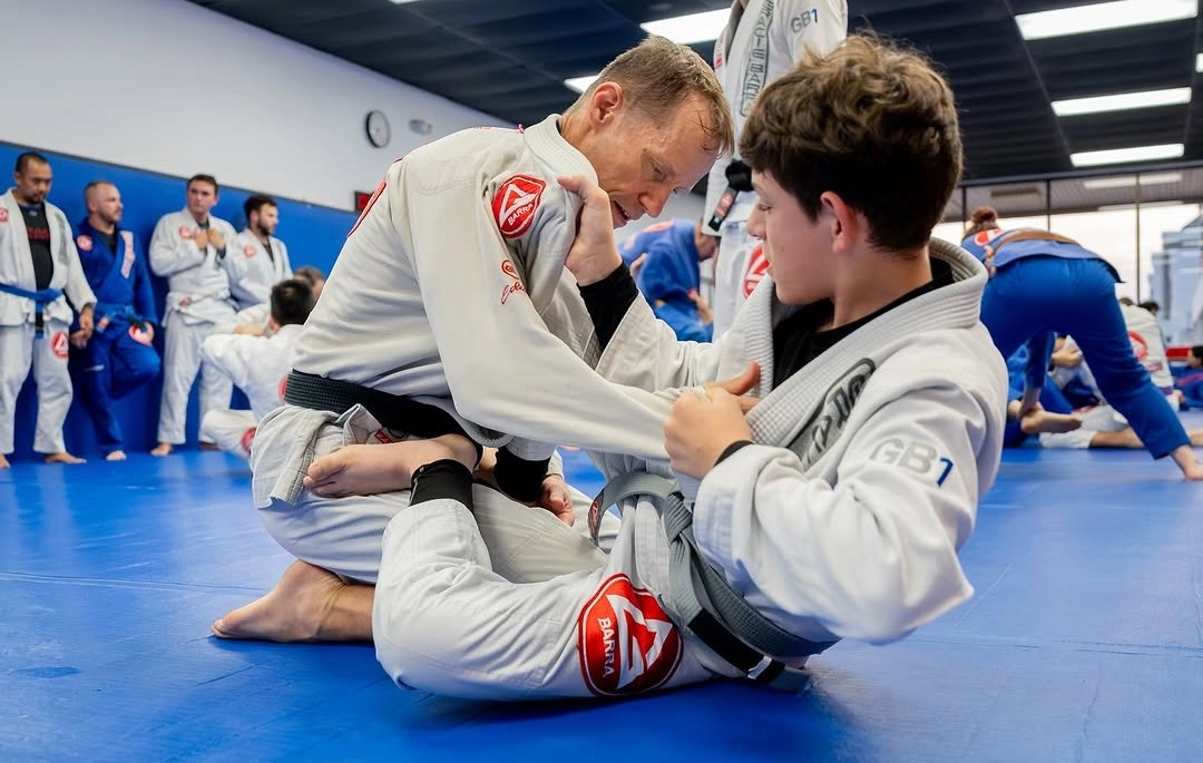 Gracie Barra Pearland students practicing Brazilian Jiu-Jitsu technique on blue academy mats